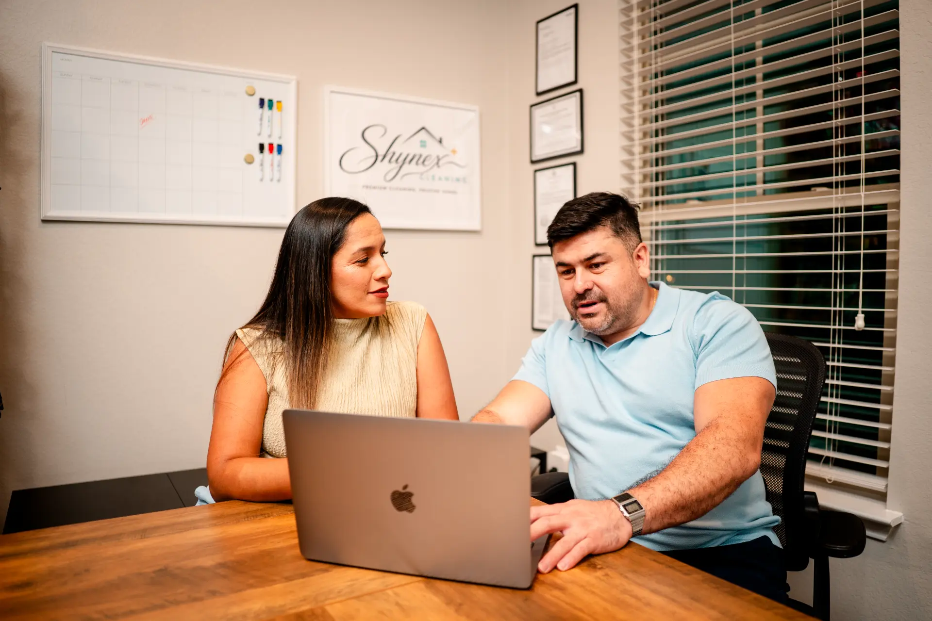 Shynex Cleaning owners reviewing schedules on a laptop